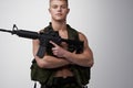 Soldier man, vest and rifle in studio portrait for military service, fight and fitness by white background. Army agent