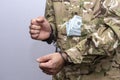 A soldier in a military camouflage uniform is handcuffed, a bundle of $100 bills sticks out of his pocket. Concept: bribery in the Royalty Free Stock Photo