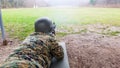 The soldier in the military department, with a helmet on his head, lies on the ground and targets the target Royalty Free Stock Photo