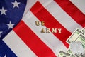 The soldier military tokens on dollar bills on the USA flag background with words US Army. Soldiers of fortune military power