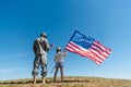 Soldier in military uniform standing near kid with american flag Royalty Free Stock Photo