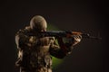 Soldier militia saboteur in military clothing with a Kalashnikov rifle on a dark background