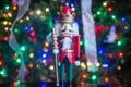 Soldier nutcracker statue standing in front of decorated Christmas tree Royalty Free Stock Photo