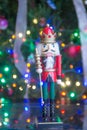 Soldier nutcracker statue standing in front of decorated Christmas tree Royalty Free Stock Photo