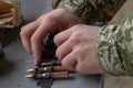 A soldier operator equips a machine-gun belt Royalty Free Stock Photo