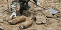 Military personnel extracting live mortar shell during demining operation Royalty Free Stock Photo