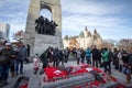 Soldier putting remembrance poppy in front of a Crowd gathering on National War memorial, on remembrance day