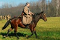 A soldier-reenactor rides a brown horse