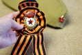 A soldier`s cap with a star and a St. George ribbon in the form of a flower on a linen background for Victory Day on May 9. Transl