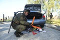 Soldier searching personal belongings of suspect near a stopped car. Checkpoint, training. Ukraine