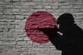 Soldier silhouette on the old brick wall with flag of japan country