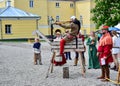 A soldier sitting on a wooden horse shoots from a crossbow