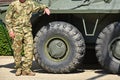 Soldier stands next to an armored military vehicle