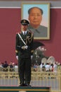 A soldier stands to attention as the portrait of Mao Zedong looks over his shoulder from the Tiananmen Gate in Beijing, China