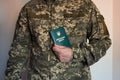 Soldier in tactic suit holds closed military id in hand.