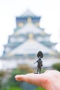 Soldier toy on hand with blurred Osaka Castle as background Royalty Free Stock Photo