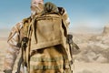 Soldier in uniform holding backpack on desert background Royalty Free Stock Photo