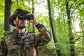 Soldier wearing camouflage uniform using binoculars in forest Royalty Free Stock Photo