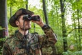 Soldier looking through binoculars while patrolling in forest Royalty Free Stock Photo