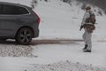 Soldier in winter camouflaged uniform in Modern warfare army on a snow day on forest battlefield with a rifle. Model