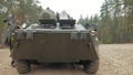 Soldiers in camouflage with combat weapons in the forest near the battle car, military concept