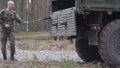 Soldiers in camouflage with combat weapons in the forest near the battle car, military concept