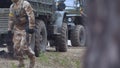 Soldiers in camouflage with combat weapons in the forest near the battle car, military concept