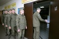 Soldiers standing in a line getting machine guns and ammunition at the gun room. Novo-Petrivtsi military base, Ukraine