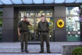 Soldiers guarding the main entrance to the building of the embassy of Germany, coat of arms on a background
