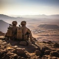 Soldiers seated atop desert cliff, embodying strength and camaraderie