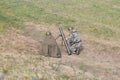 Soldiers in Soviet uniforms on the battlefield, charging mortar, from the back