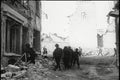 Soldiers walking through bombed out building