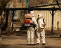 Soldiers in a white protective suits sprays the streets and courtyards with disinfectant to decontaminate the city of the