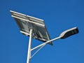 A sole solar street light during a clear sunny morning. Large solar panel mounted on top of the pole. Optical weather conditions