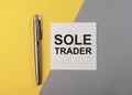 SOLE TRADER TEXT ON NOTE on table, top view