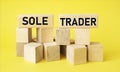 Sole trader on wooden blocks and yellow background. Royalty Free Stock Photo