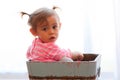 Solemn baby girl in wooden box Royalty Free Stock Photo