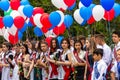 Solemn meeting last bell for graduates in a Russian school, school graduates with colored balloons in their hands in the schoolyar