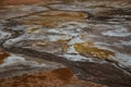 Solfatare mudpot s in the geothermal area Hverir, Iceland. The area around the boiling mud is multicolored and cracked