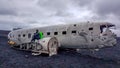Iceland - Young man sitting on an airplane wreck