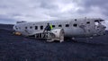 Iceland - Young man sitting on an airplane wreck