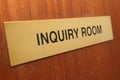 Inquiry room sign on a wooden door.