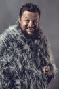 Solid bearded man in a fur mantle studio emotional Royalty Free Stock Photo