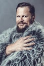Solid bearded man in a fur mantle studio portrait Royalty Free Stock Photo