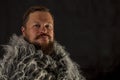 Solid bearded man in a fur mantle studio portrait Royalty Free Stock Photo