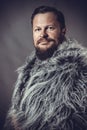Solid bearded man in a fur mantle studio portrait Royalty Free Stock Photo