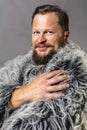 Solid bearded man in a fur mantle studio portrait Royalty Free Stock Photo