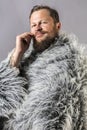 Solid bearded man in a fur mantle studio portrait Royalty Free Stock Photo