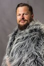 Solid bearded man in a fur mantle studio portrait Royalty Free Stock Photo