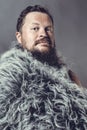 Solid bearded man in a fur mantle studio portrait Royalty Free Stock Photo